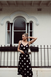 a lady in a black slip dress with white polka dots